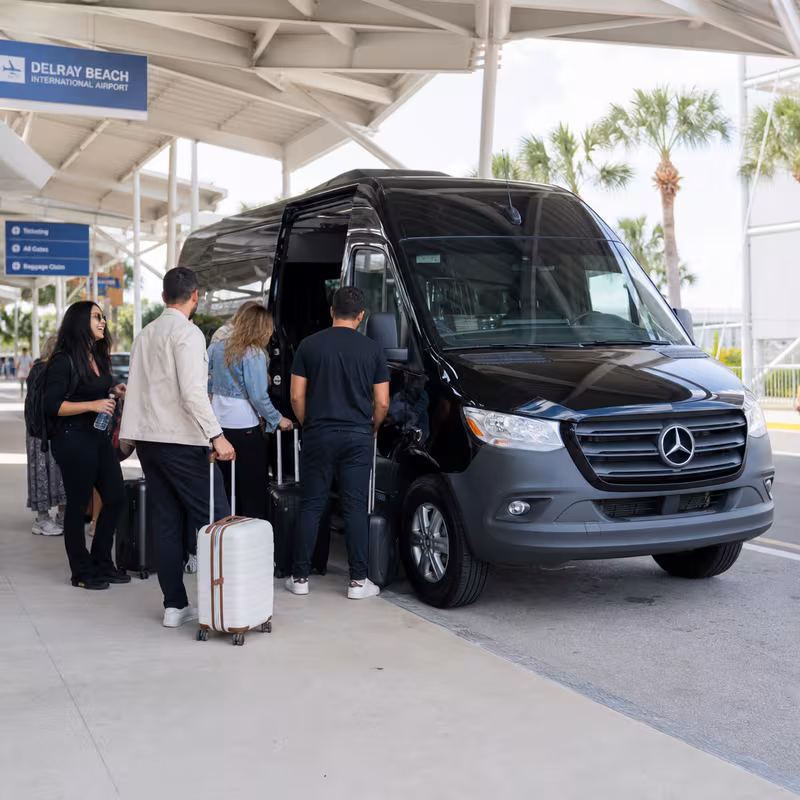 Group boarding a white charter bus for Airport Transportation transportation in Delray Beach
