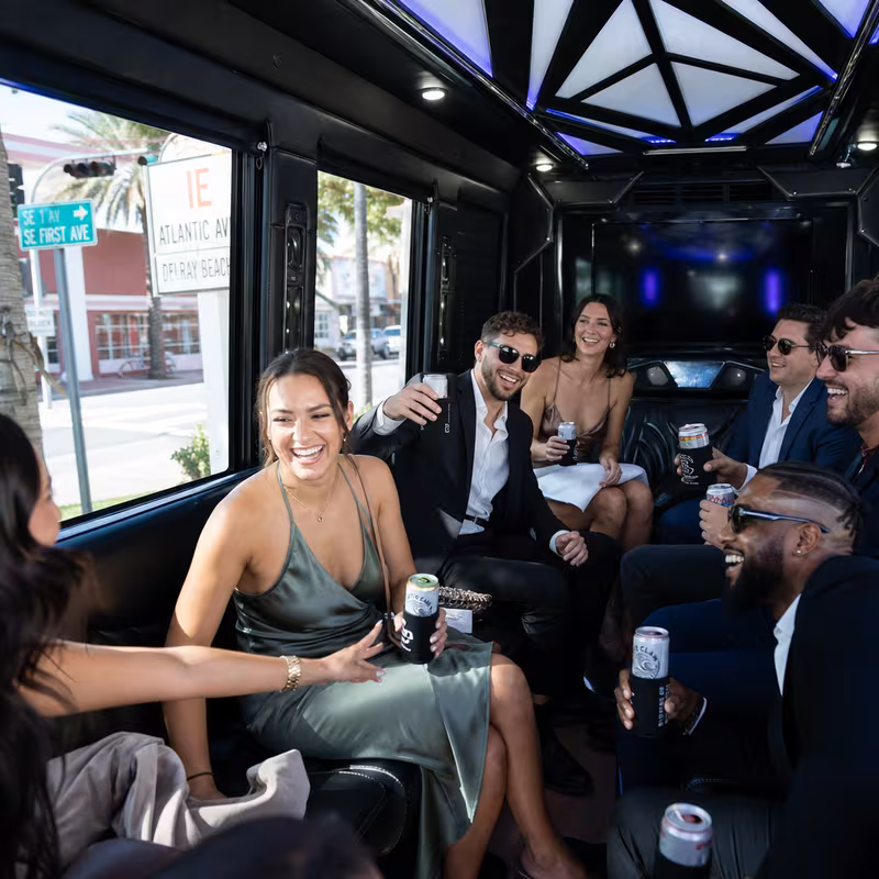 Party bus interior with wraparound leather seating and LED lighting in Delray Beach