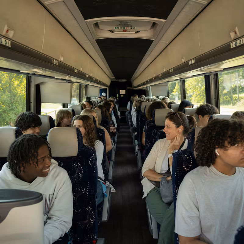 Group boarding a white charter bus for School Transportation transportation in Delray Beach